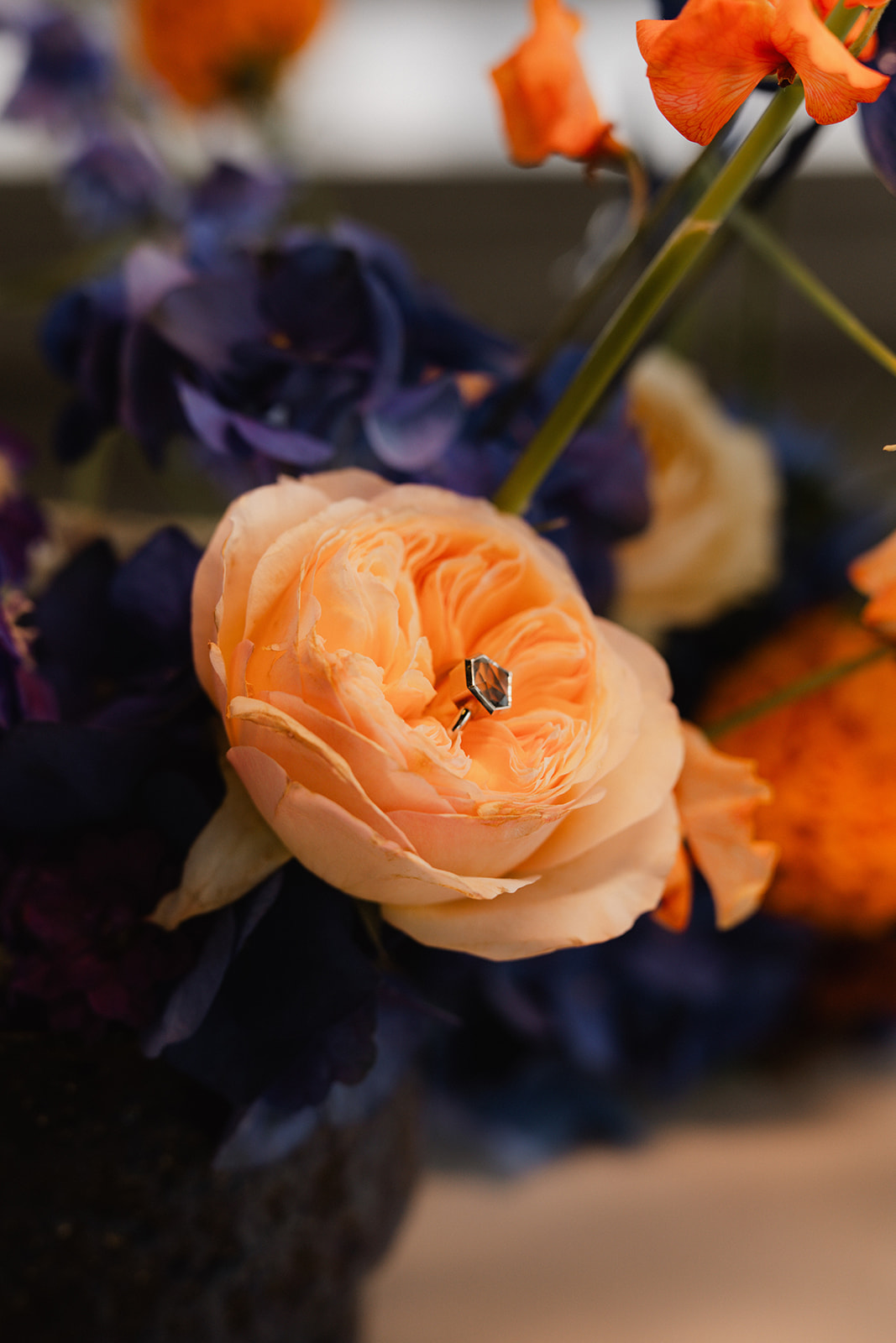 Trauring in einer Blüte, umgeben von einem Brautstrauß