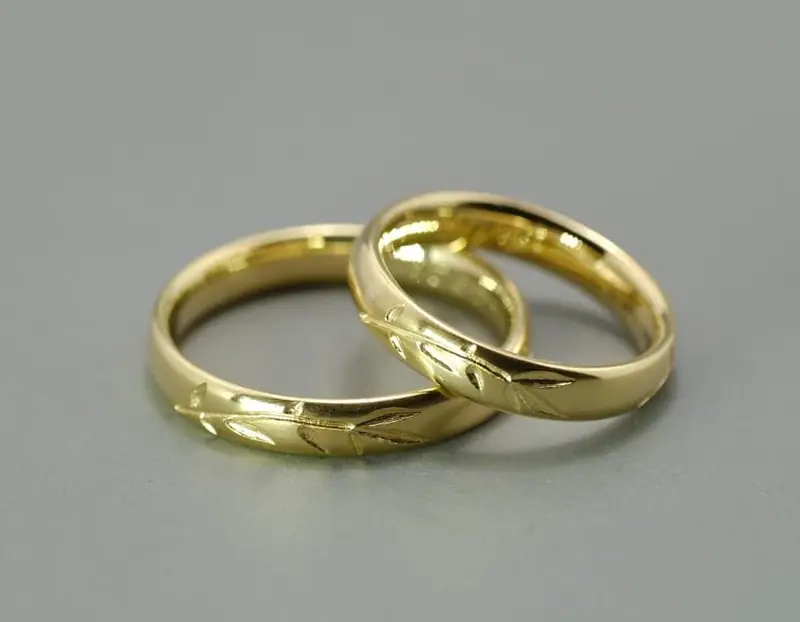 Zwei Trauringe aus Gelbgold mit graviertem Zweig