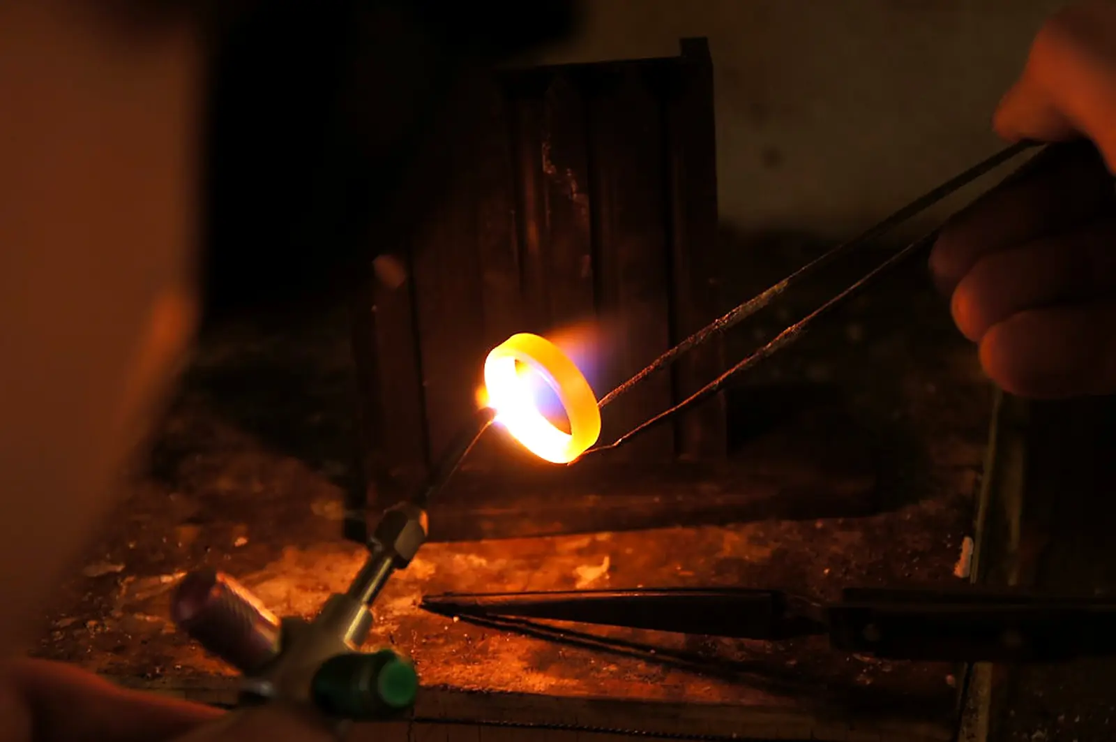 Arbeit mit Flamme und glühendem Metall in der Werkstatt